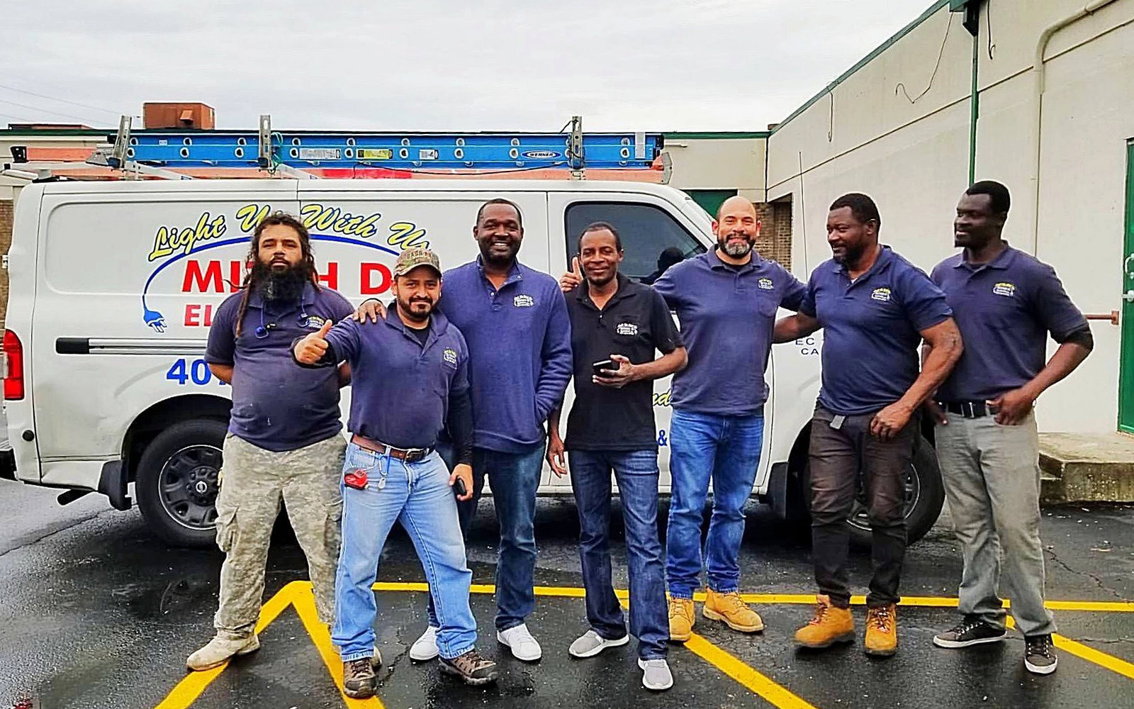 The Mitch D. Electric team in front of a company van